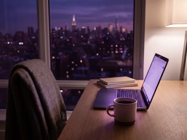 Illustrative image: laptop by the window at night above the city